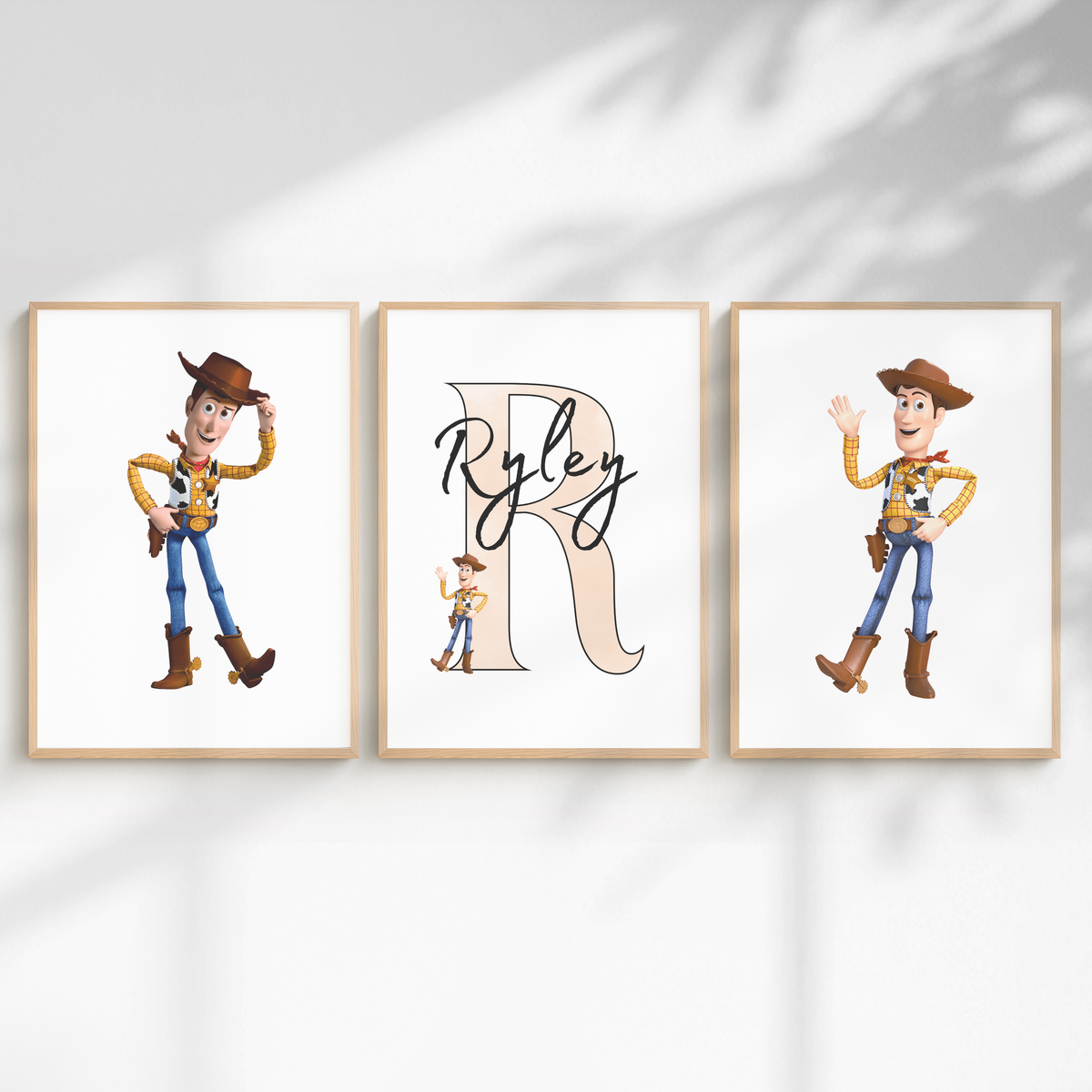 Three framed wall art prints displayed side by side on a white wall with soft shadow overlays. The center print features a large beige letter R with the name Ryley in black script, and the side prints show Woody the cowboy from Toy Story in two different poses.