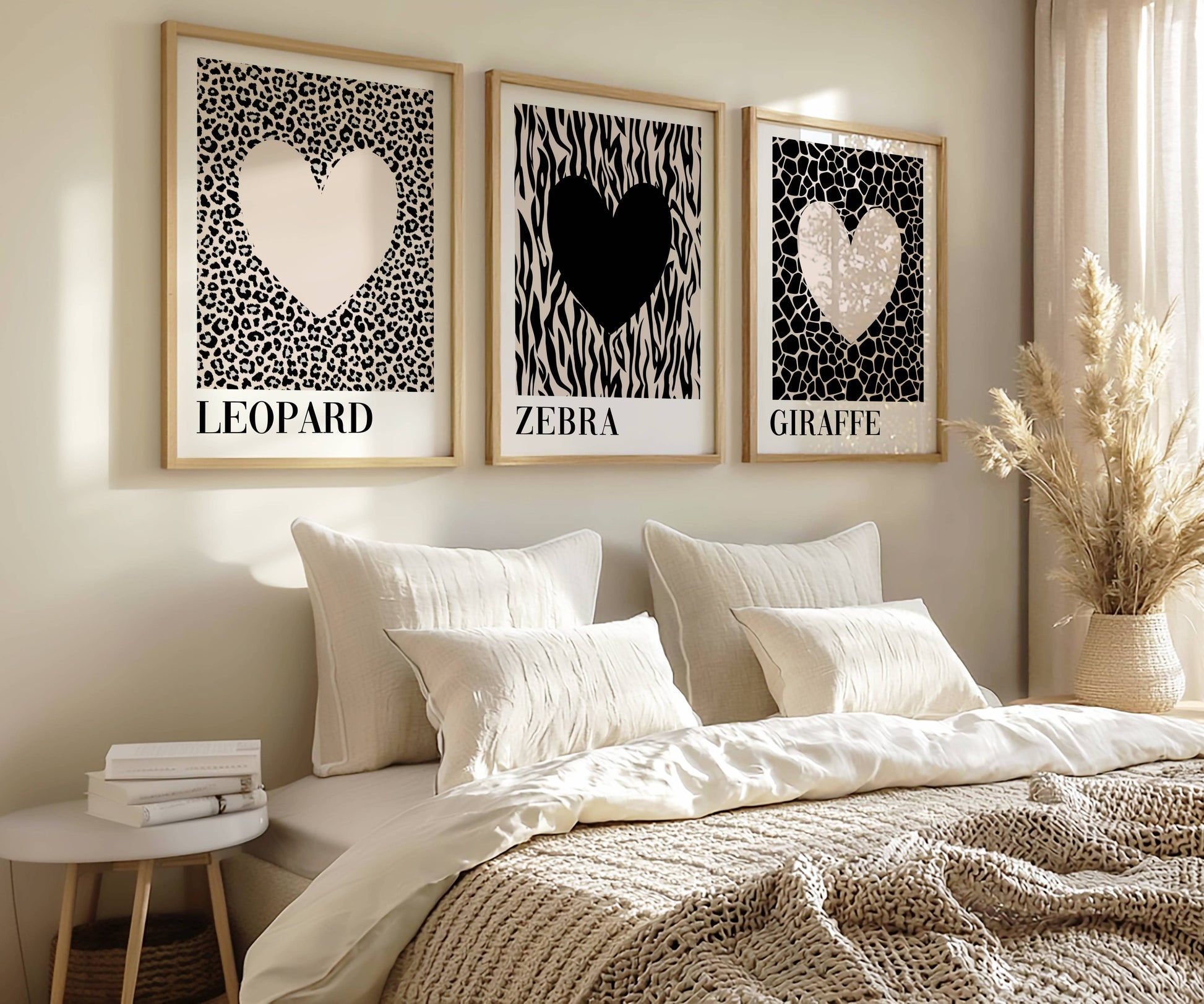 Modern bedroom styled with neutral safari wall art featuring leopard, zebra and giraffe heart prints above a soft cream bed in a Scandinavian-inspired interior.