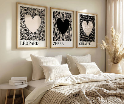 Modern bedroom styled with neutral safari wall art featuring leopard, zebra and giraffe heart prints above a soft cream bed in a Scandinavian-inspired interior.