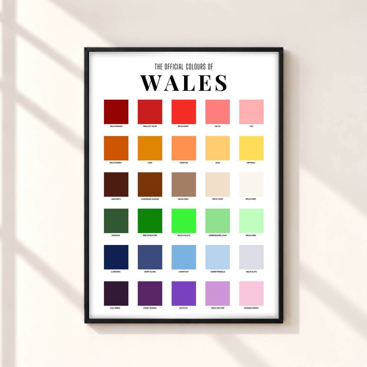 Wales colour chart print featuring 30 colourful squares labelled with Welsh places, foods, symbols and sayings beneath The Official Colours of Wales heading.
