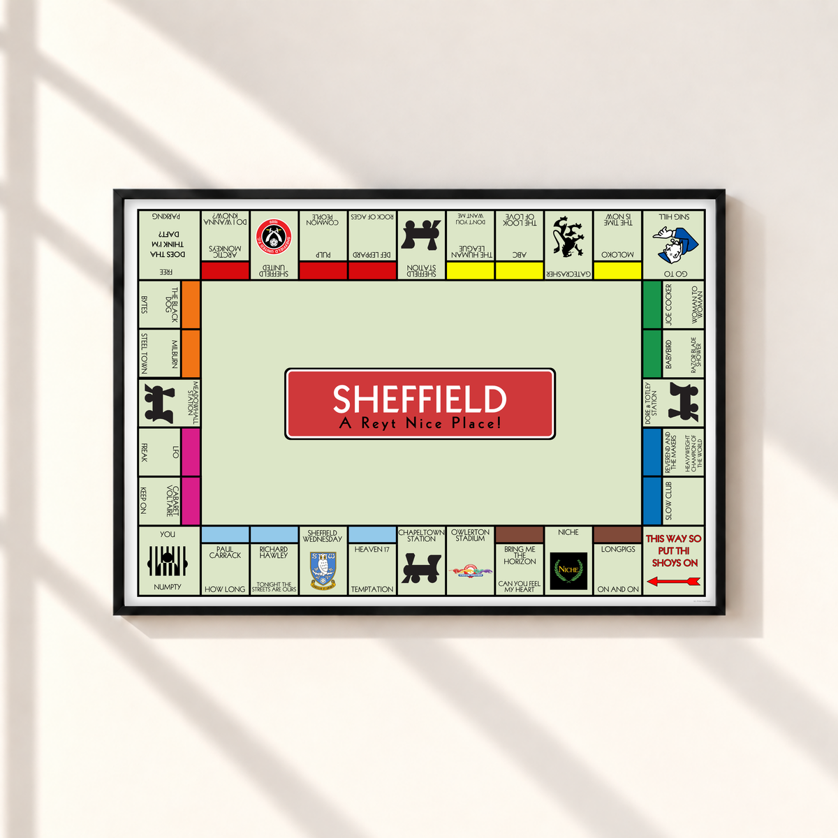 Sheffield Monopoly-style wall art print in a thin black landscape frame, featuring local bands, football clubs and Yorkshire sayings on a pale green background.