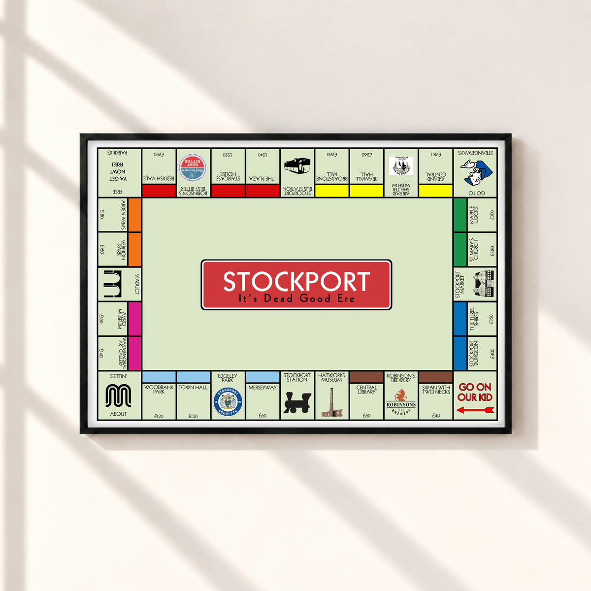 Stockport Monopoly inspired wall art print featuring famous Stockport landmarks and Northern sayings in a black landscape frame on a neutral wall