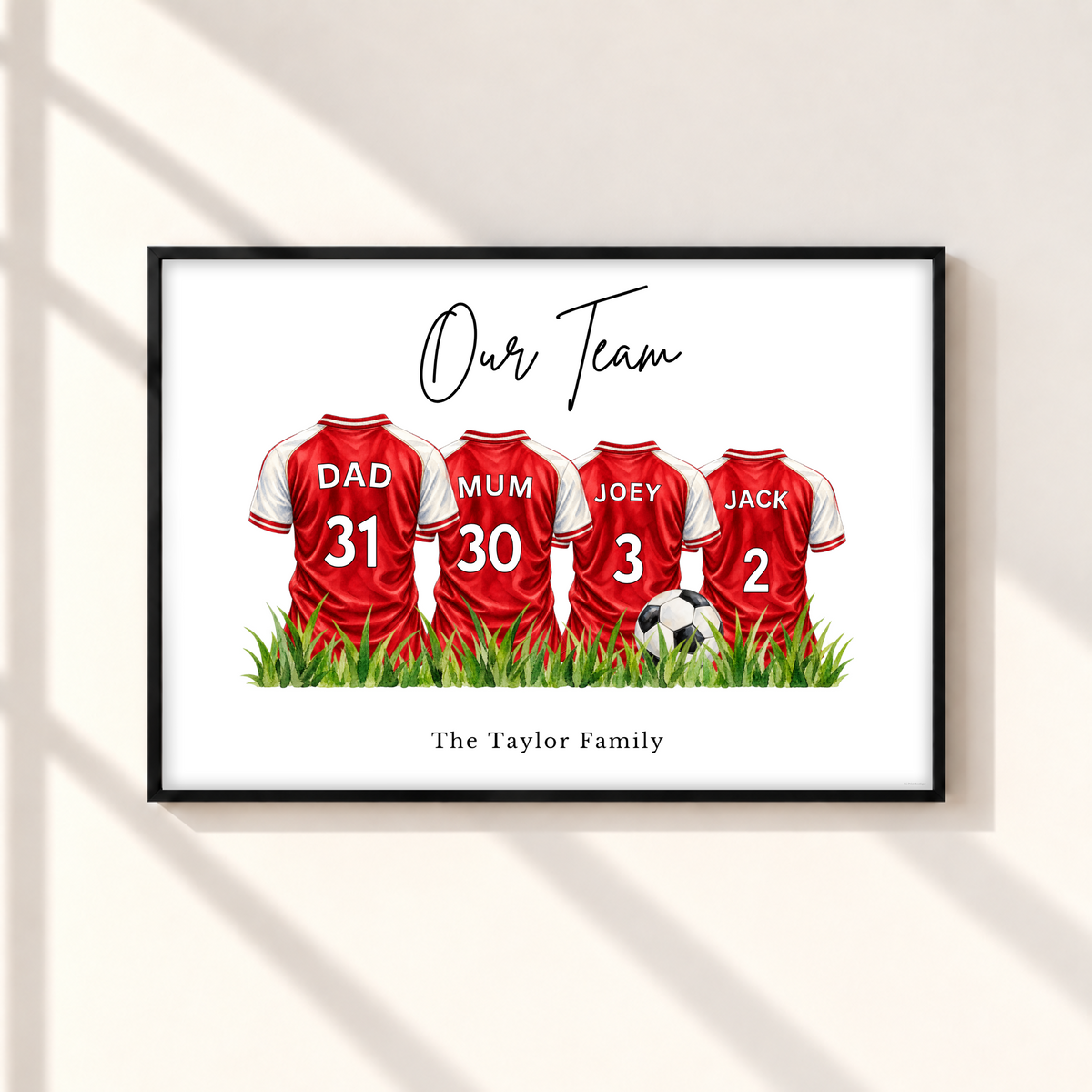 Personalised Arsenal inspired family football print with four red and white custom name and number shirts in black frame.