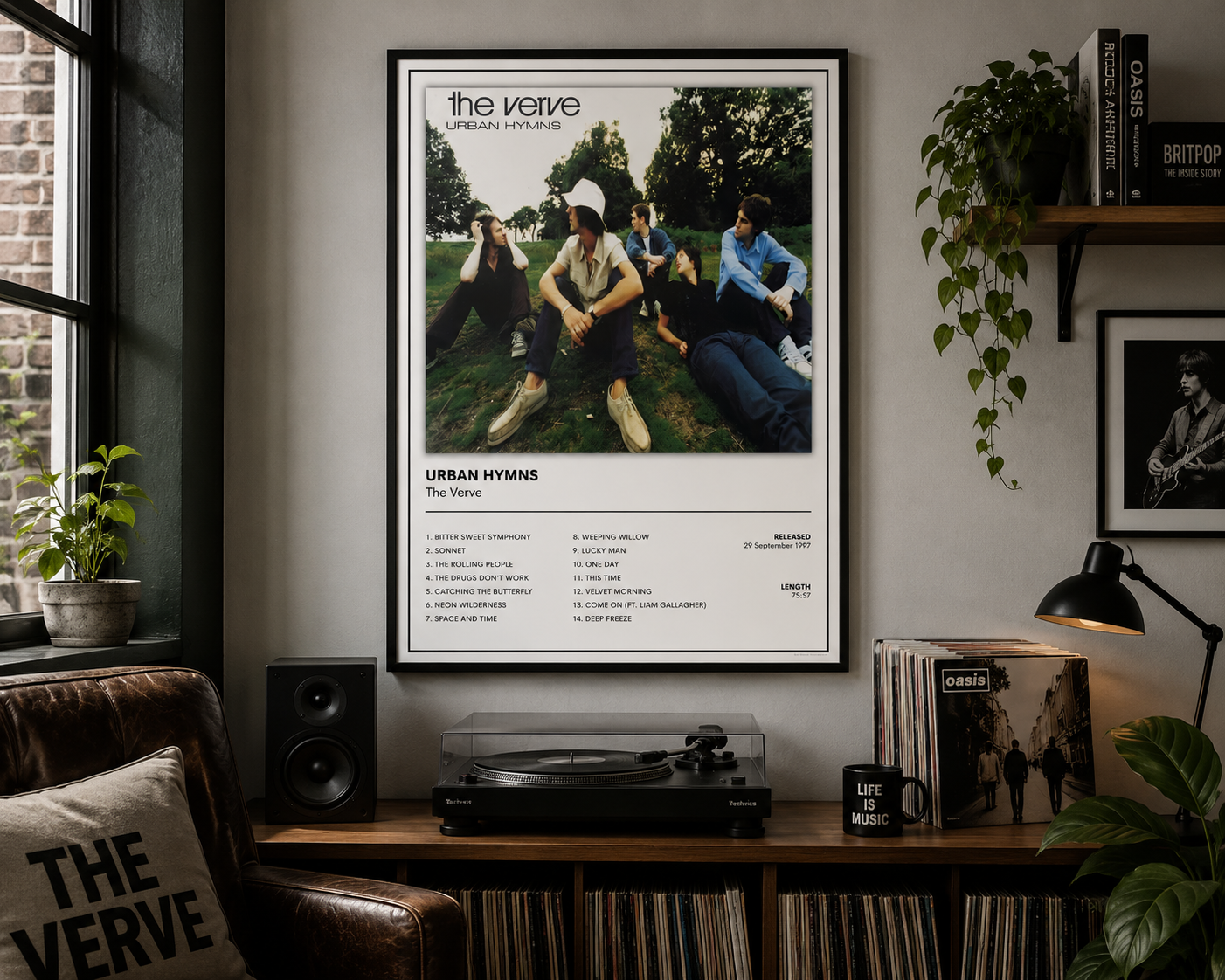 A framed music poster for 'The Verve - Urban Hymns' hanging on a gray wall in a styled room with a record player, plants, and shelves.