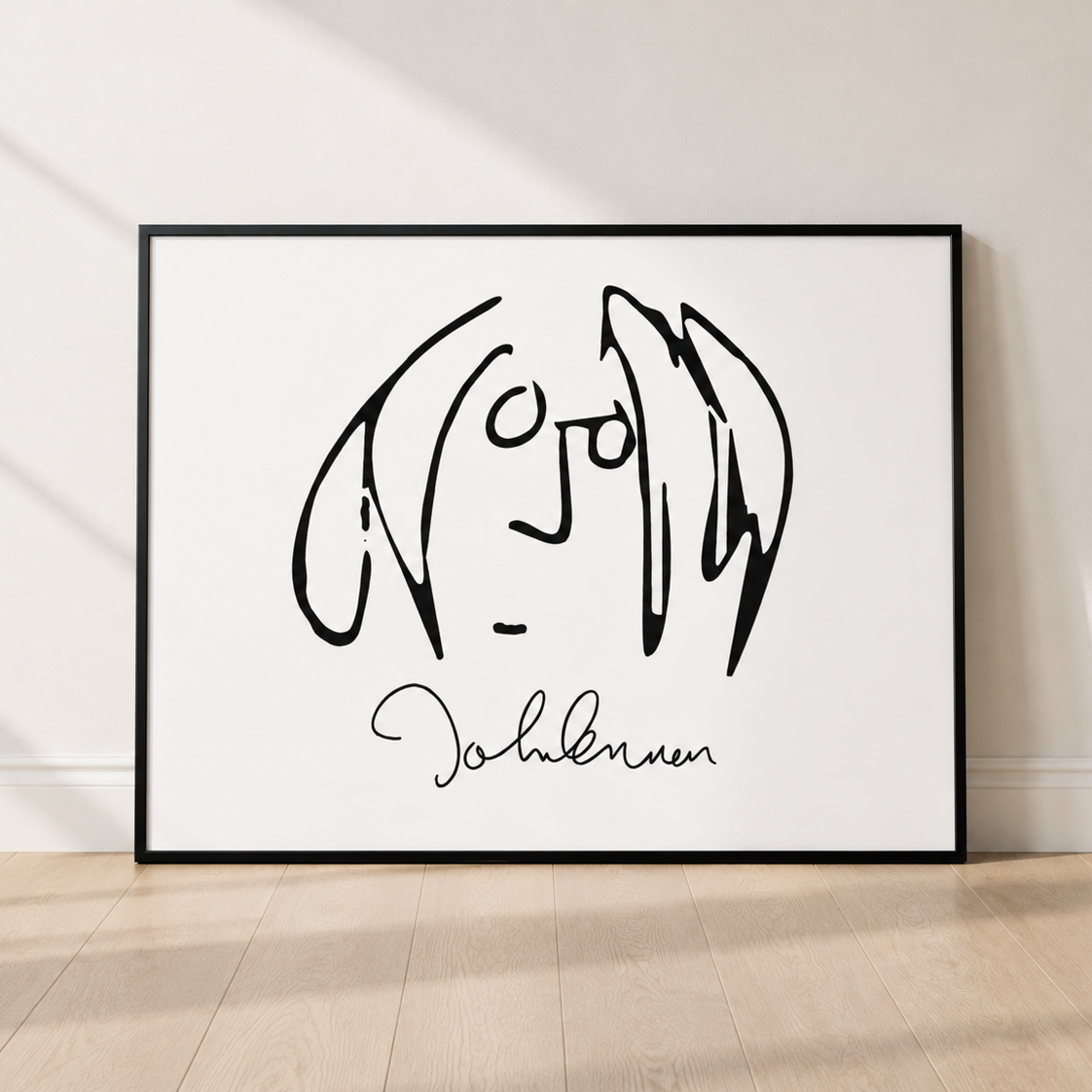 A framed minimalist black line art print of John Lennon's face and signature, leaning against a light beige wall on a light wood floor.