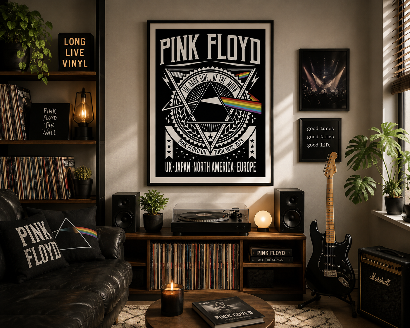 A framed Pink Floyd 'The Dark Side of the Moon' poster hangs on a wall in a cozy, dimly lit music room. The room features a black leather couch with a matching pillow, a wooden record shelf with speakers and a turntable, a black electric guitar, and a Marshall amp.