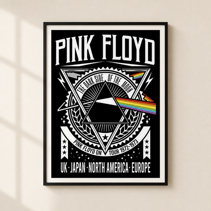 A framed Pink Floyd 'The Dark Side of the Moon' poster hanging on a light beige wall. The poster features a black background with white text and graphics, including the band name 'PINK FLOYD', a triangular prism design, and a rainbow light beam.