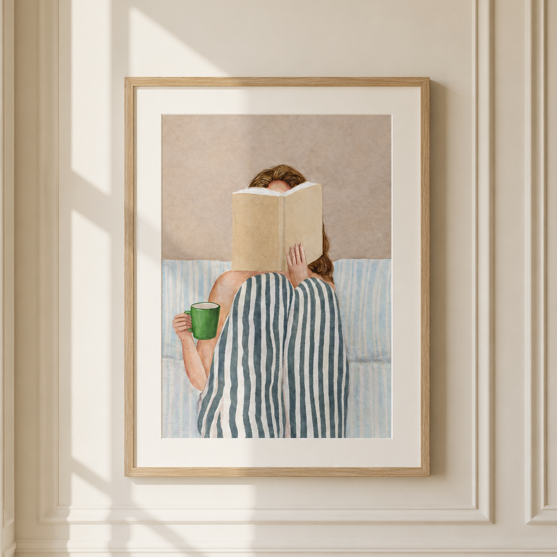 Book lover wall art featuring a cosy reading scene with coffee in a light oak frame for a neutral bedroom.