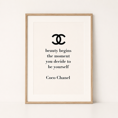 Coco Chanel quote wall art featuring the quote "Beauty begins the moment you decide to be yourself" in a light oak frame.