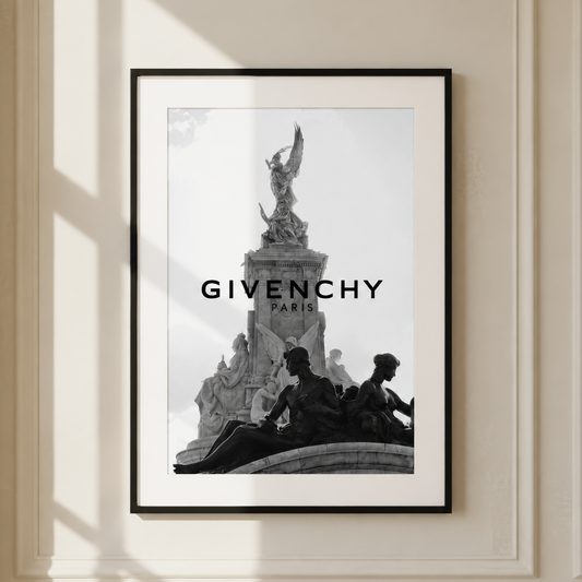 A framed black and white art print featuring a Givenchy Paris monument with the brand name 'GIVENCHY PARIS' printed across the center, displayed on a cream-colored paneled wall with soft window shadows.