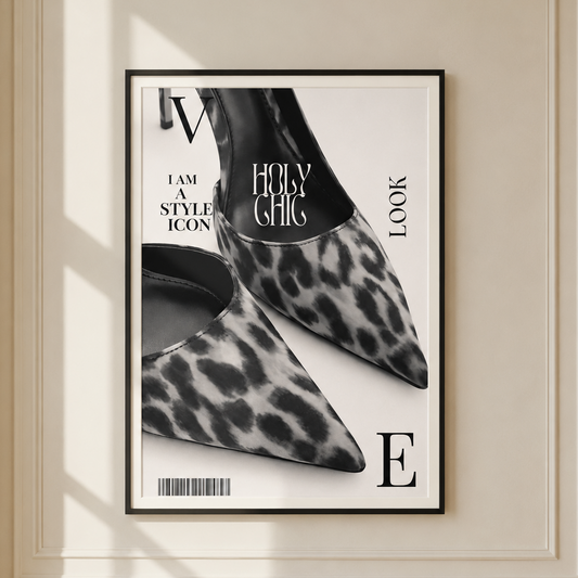 A framed fashion poster featuring a black and white leopard-print pointed shoe design with bold typography, displayed on a cream-colored paneled wall with soft window shadows.