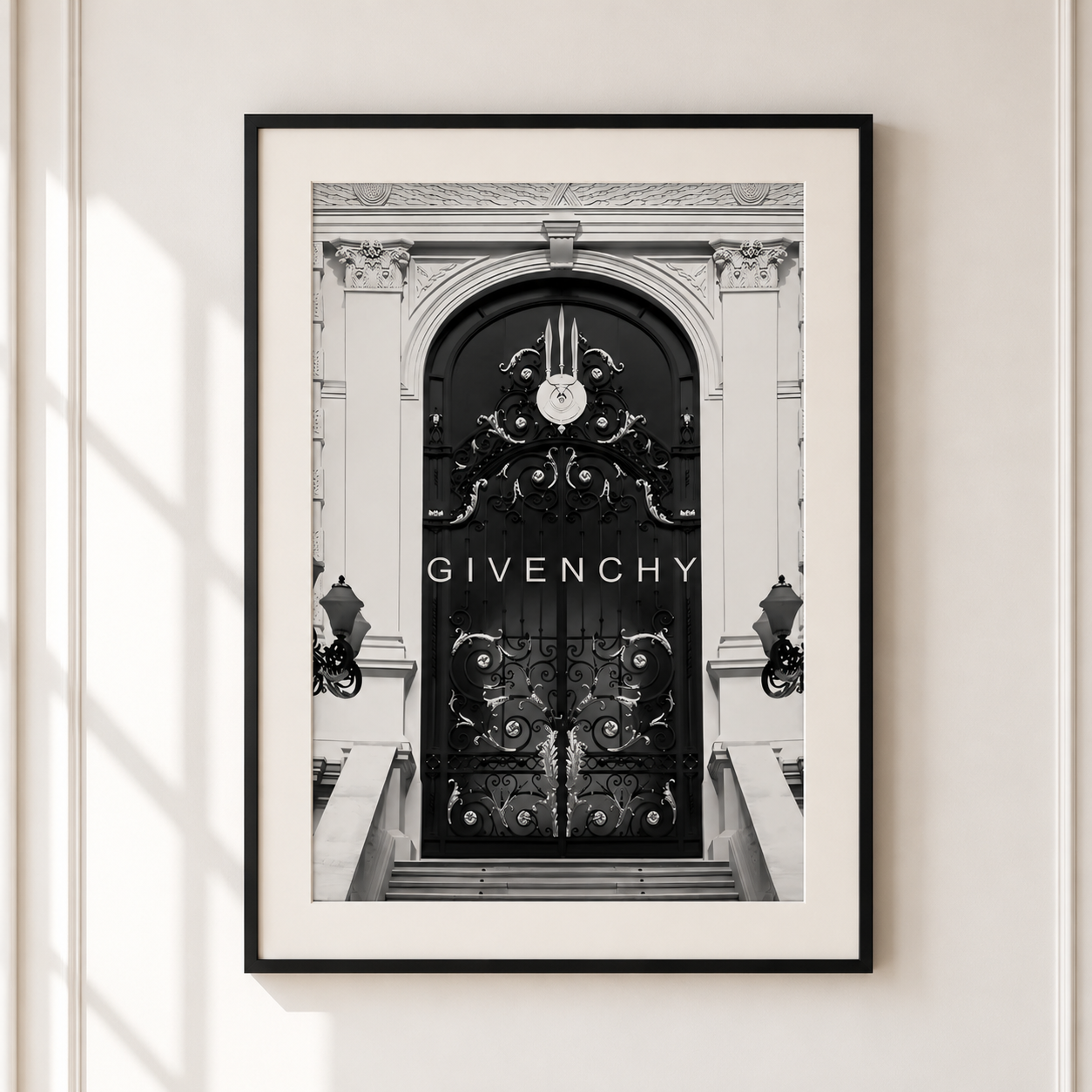 A framed black and white art print of a Givenchy door, featuring the brand name 'GIVENCHY' in white text on the dark door. The print is framed in black with a white mat, hanging on a light beige wall.