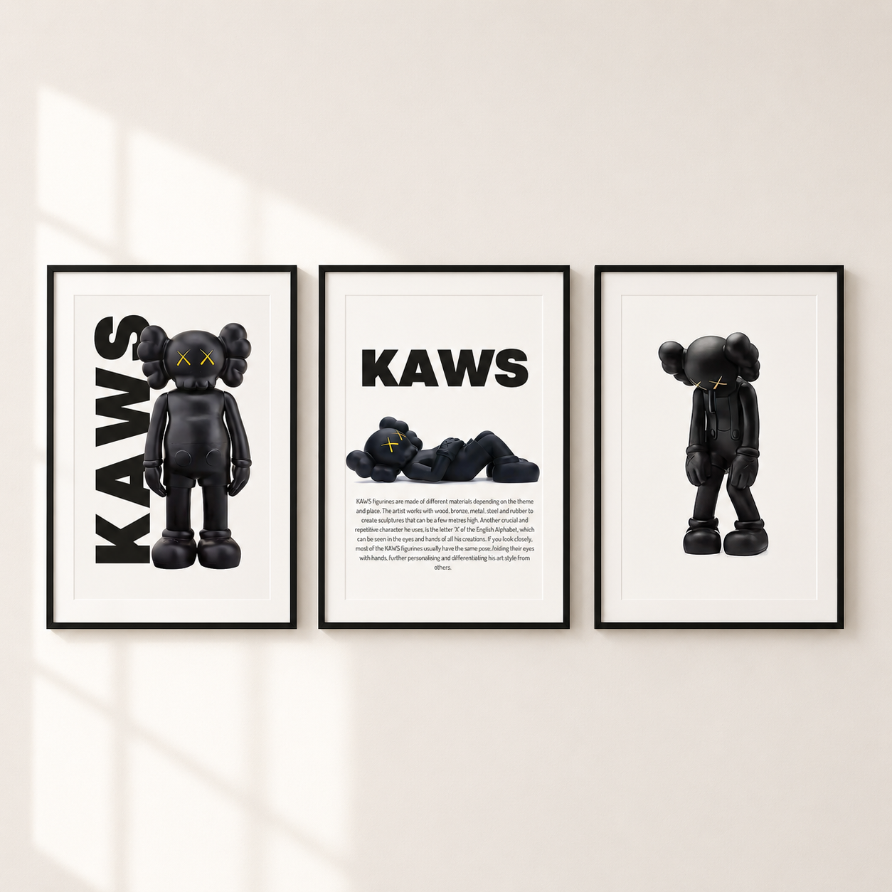 Three framed wall art prints featuring a black KAWS character design, displayed side by side on a light beige wall with soft window shadows.