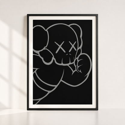 A framed art print featuring a minimalist black and white line drawing of a bear with an X for a eye, styled leaning against a white wall with soft window shadows.