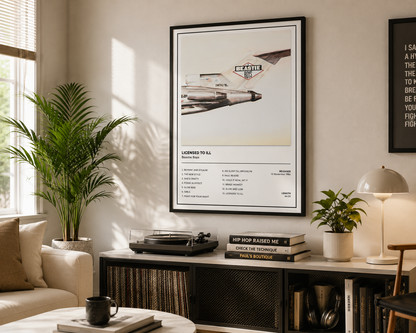 A framed poster featuring a vintage fighter jet and the text 'LEADER TO 54' hanging on a wall in a styled living room with a sofa, plant, lamp, and records on a console table.