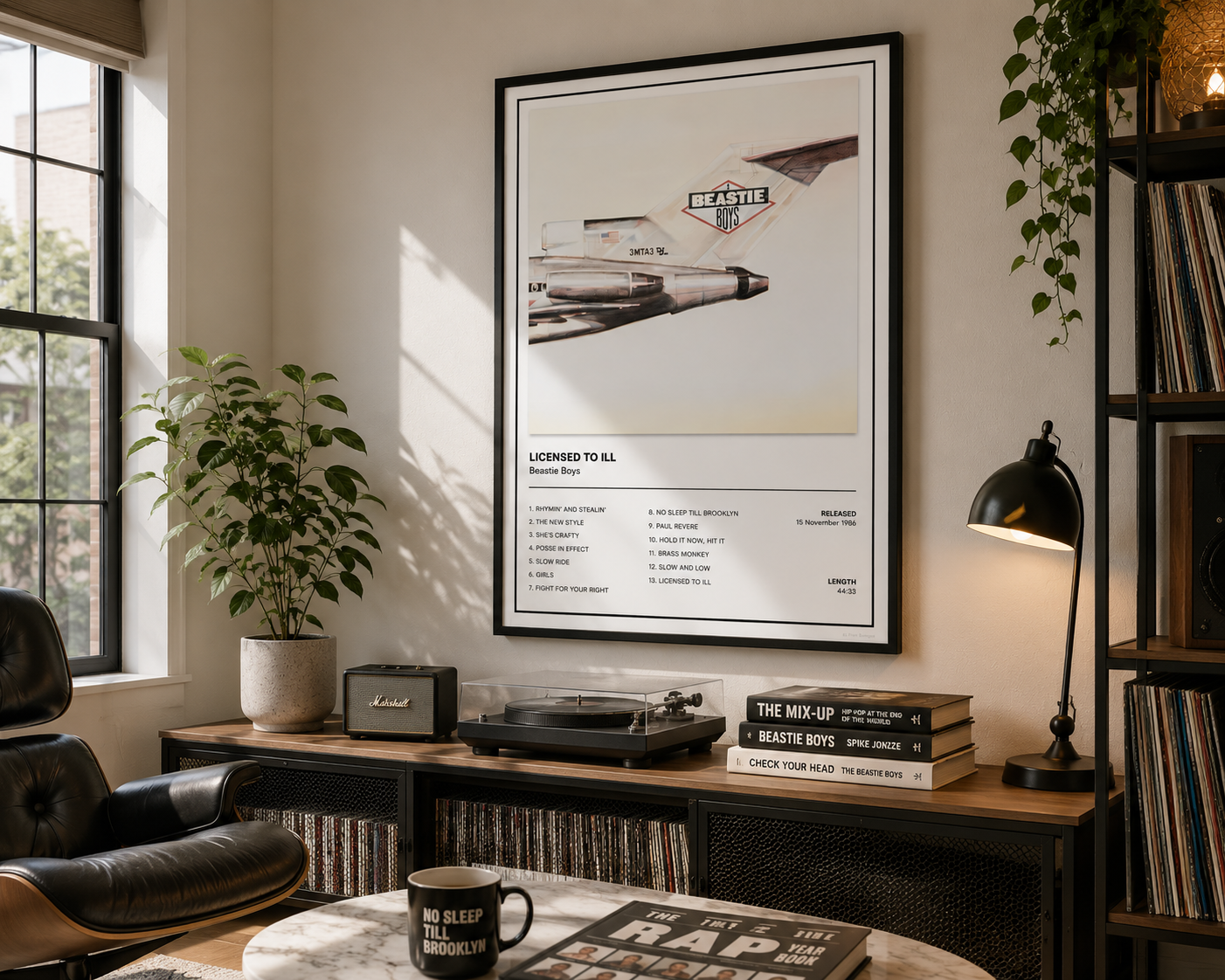 A framed music poster featuring a vintage airplane and the text 'LOVED TO SEE BEASTIE Boys Own' hangs on a wall in a styled room with a desk, lamp, plants, and records.