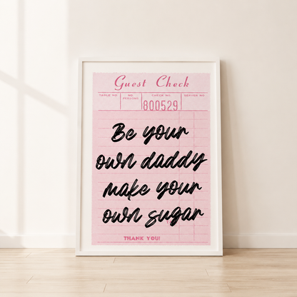 Framed pink print with black text on a light wooden floor.