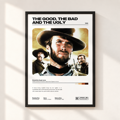 A framed movie poster for 'The Good, The Bad and The Ugly' hangs on a light beige wall. The poster features a black frame, a white background, and a stylized retro graphic of Clint Eastwood's character with a cowboy hat and beard, along with film credits and release details.