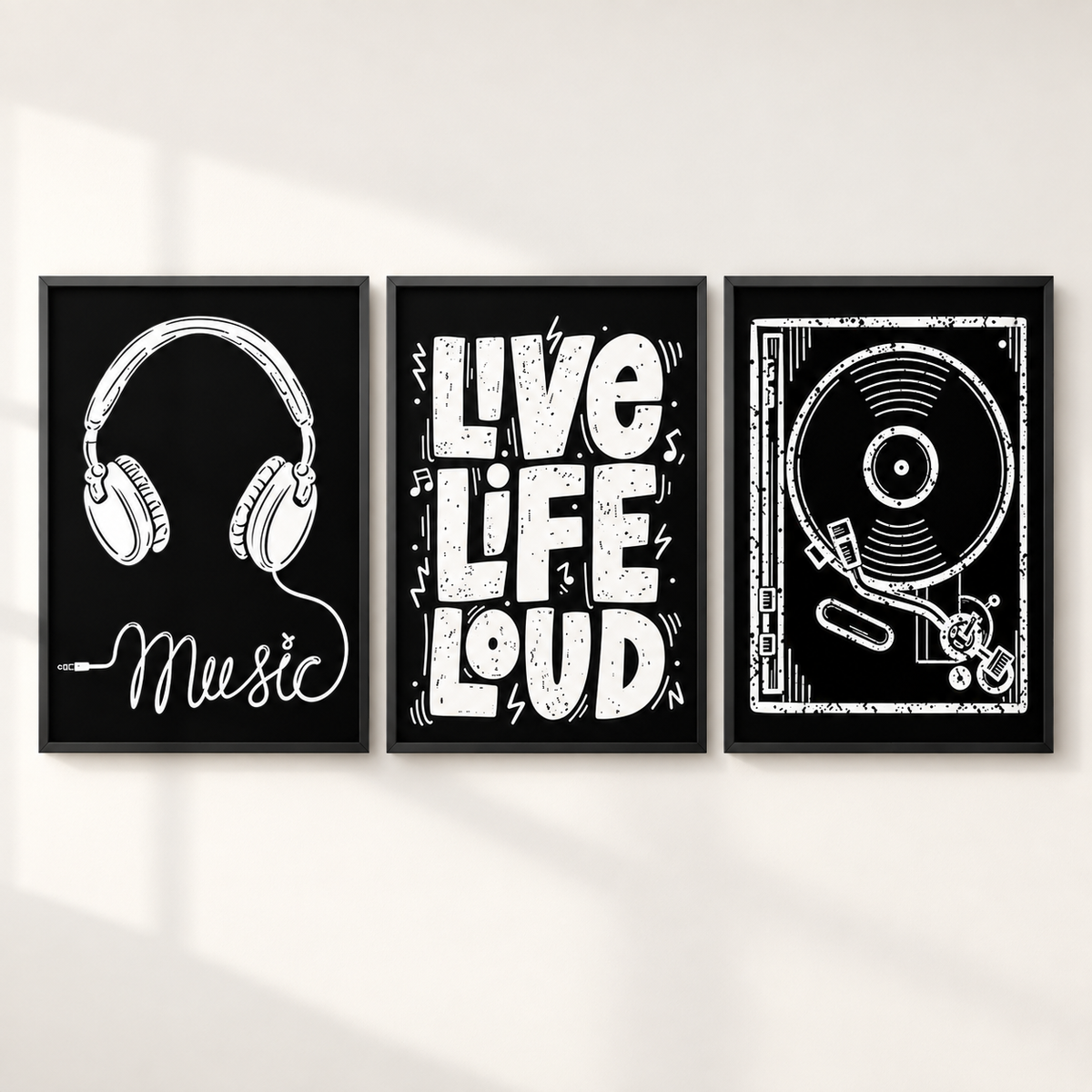 Three framed black-and-white music-themed wall art prints hang on a light wall. The left print shows headphones with the word 'Music'; the center print reads 'LIVE LIFE LOUD'; the right print shows a vinyl record and turntable.