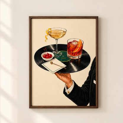 A framed art print hanging on a light beige wall, depicting a bartender in a black suit holding a black vinyl record tray with a martini glass, an orange cocktail, cherries, and a small gold spoon. The print is shown with soft window shadow overlays on the left side.