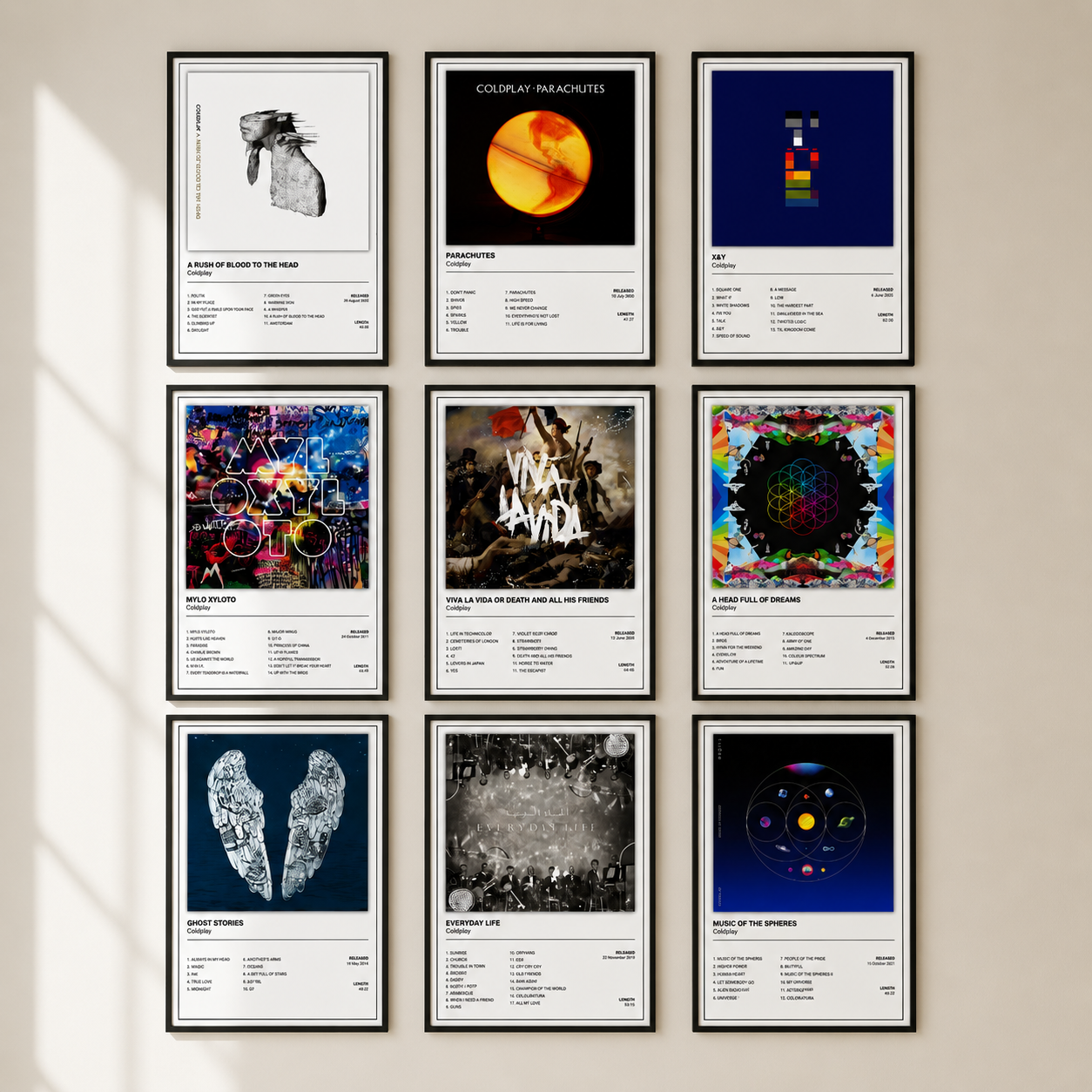 Nine framed Coldplay music posters arranged in a 3x3 grid on a beige wall, featuring various artist album covers and track art prints.