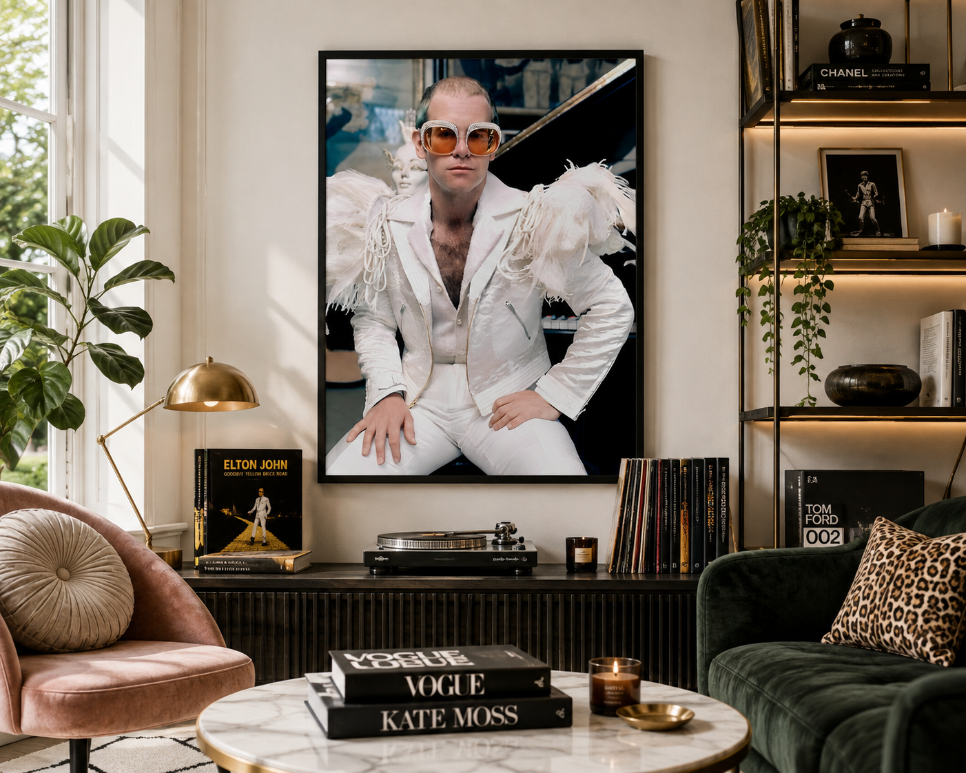 A large framed vertical art print of Elton John in a white suit hangs on a beige wall in a styled living room with a pink armchair, green sofa, and coffee table.