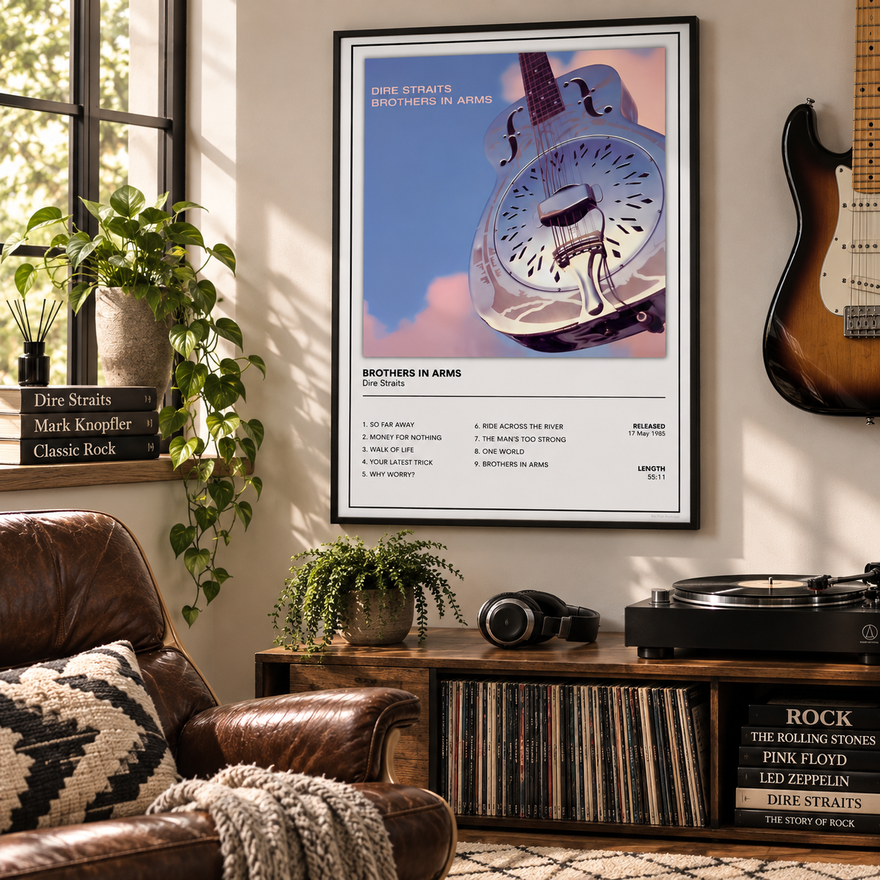 A framed music poster for Dire Straits's 'Bothers in Arms' hangs on a beige wall in a styled living room. The poster features a surreal illustration of a clock face inside a bird silhouette against a pink sky.