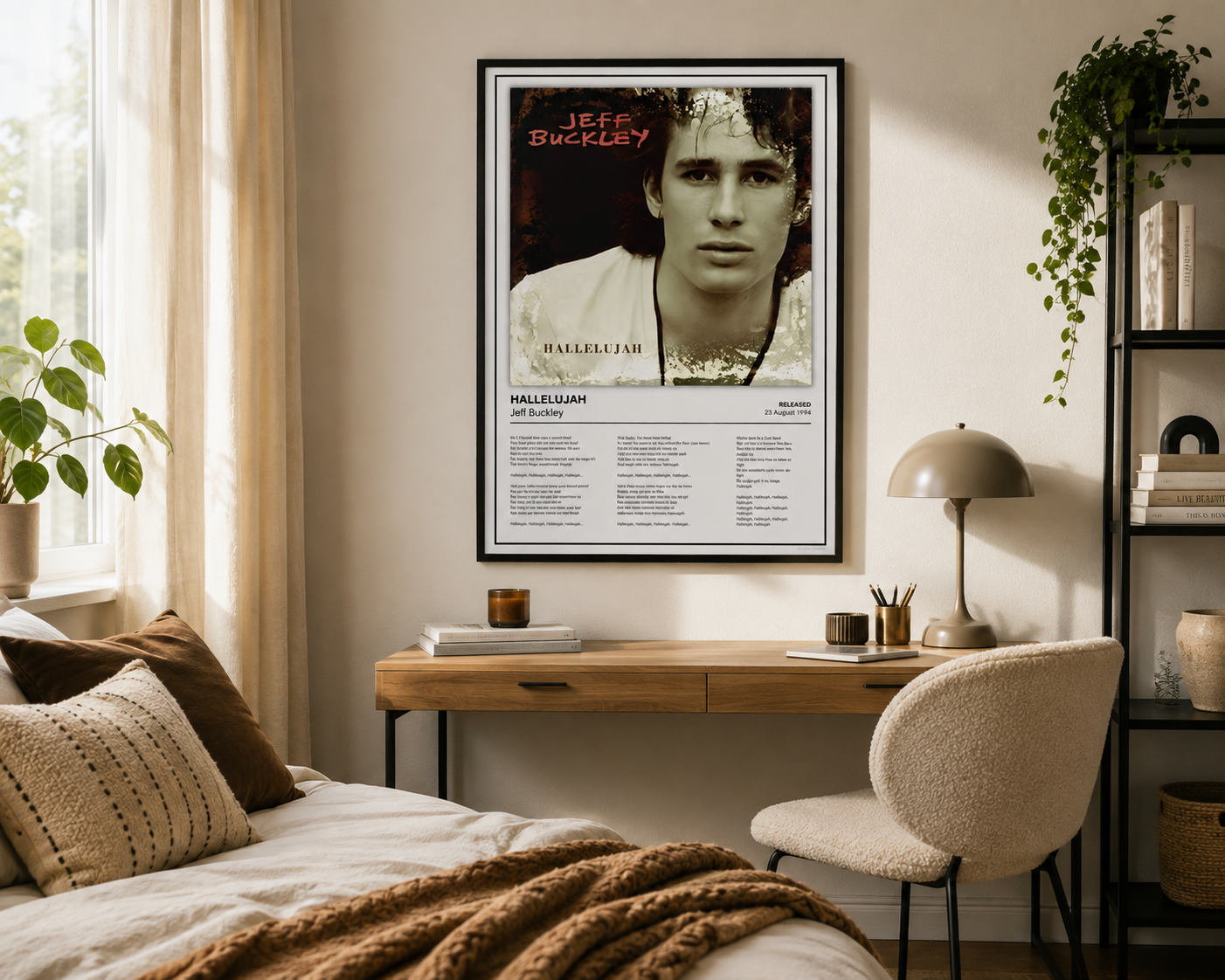 A framed Jeff Buckley 'Mellow Blue' poster hangs on a beige wall in a styled bedroom setting with a wooden desk, chair, lamp, and bed.
