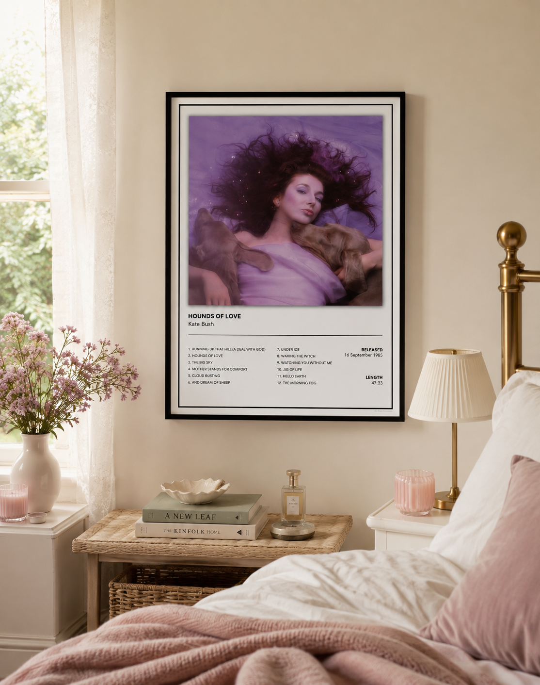 A framed art print featuring a purple-toned portrait of Kate Bush – Hounds of Love, displayed on a beige wall above a bed in a styled bedroom setting.