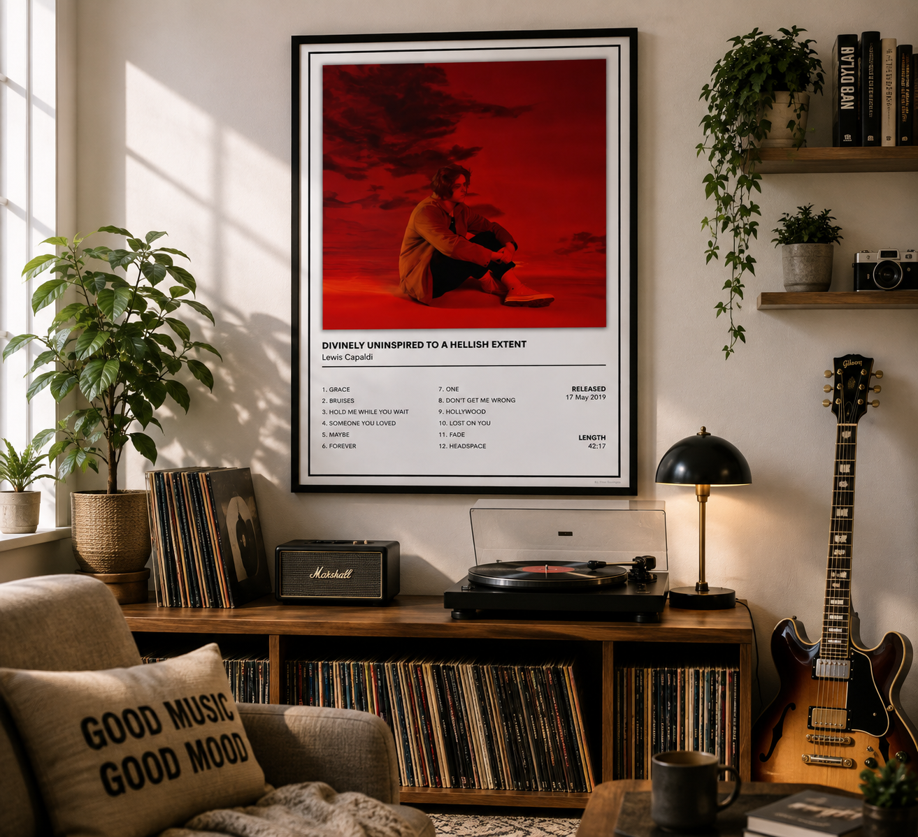 A framed music poster for Leona Carpenter's album Lewis Capaldi Divinely Uninspired To A Hellish Extent hangs on a wall in a styled music room with a record player, guitar, plants, and shelves.