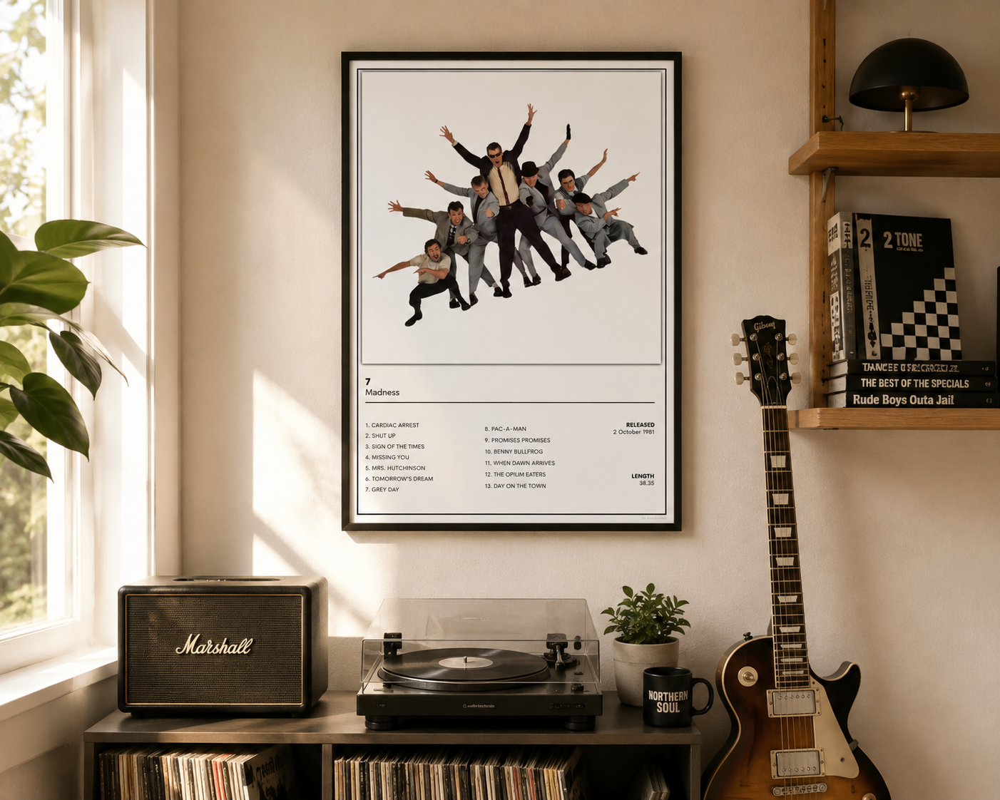 A framed music poster featuring Madness, 7 above a track list, hanging on a beige wall in a styled room with a Marshall speaker, turntable, guitar, and shelf.