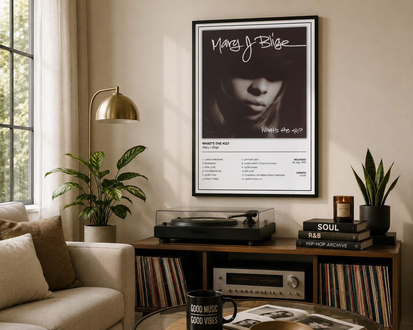 A framed Mary J Blige What’s the 411' music poster hangs on a beige wall in a styled living room setting with a record player, plants, and a sofa.