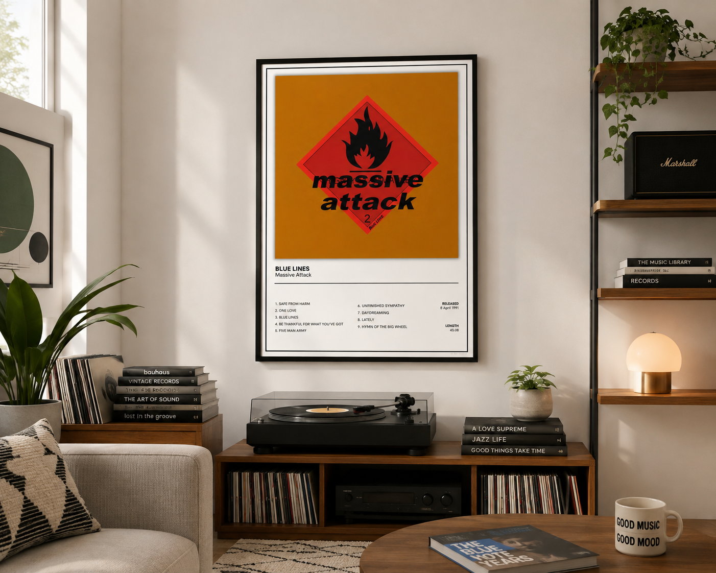 A framed music poster featuring the Blue Lines 'massive attack' artwork hanging on a wall in a styled living room with a turntable, books, plants, and shelving.