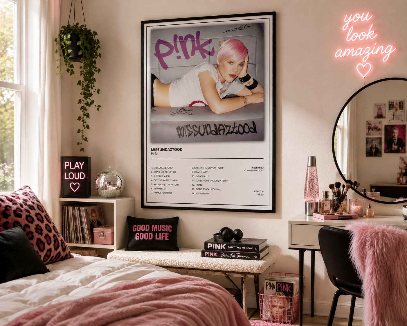 A framed Pink music poster hangs on a beige wall in a styled bedroom. The poster features a black-and-white portrait of Pink with pink hair and the text 'Pink' and 'Missed Jazzood.