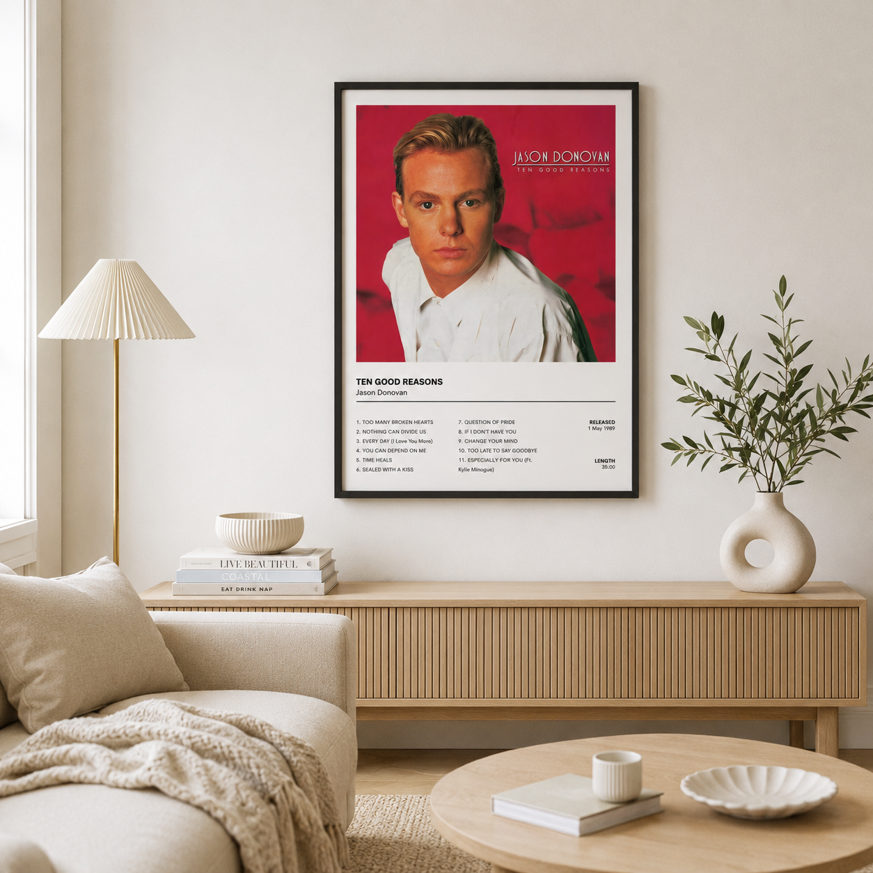 Framed Jason Donovan Ten Good Reasons album artwork displayed in a bright Scandinavian-style living room above a modern oak media unit with neutral décor.