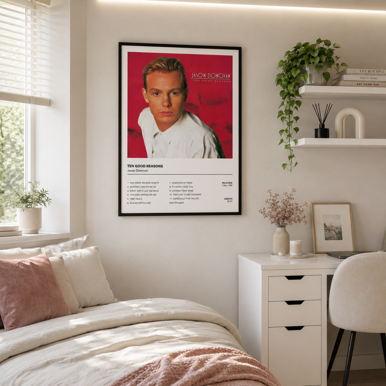Jason Donovan Ten Good Reasons album cover and tracklist wall art displayed in a light, modern bedroom home office with soft neutral furnishings and natural daylight.