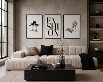 A modern living room featuring three framed black and white art prints on a textured gray wall above a cream-colored sectional sofa. The center print features the word 'FASHION' in bold letters, flanked by prints of a perfume bottle and a high-heeled shoe.