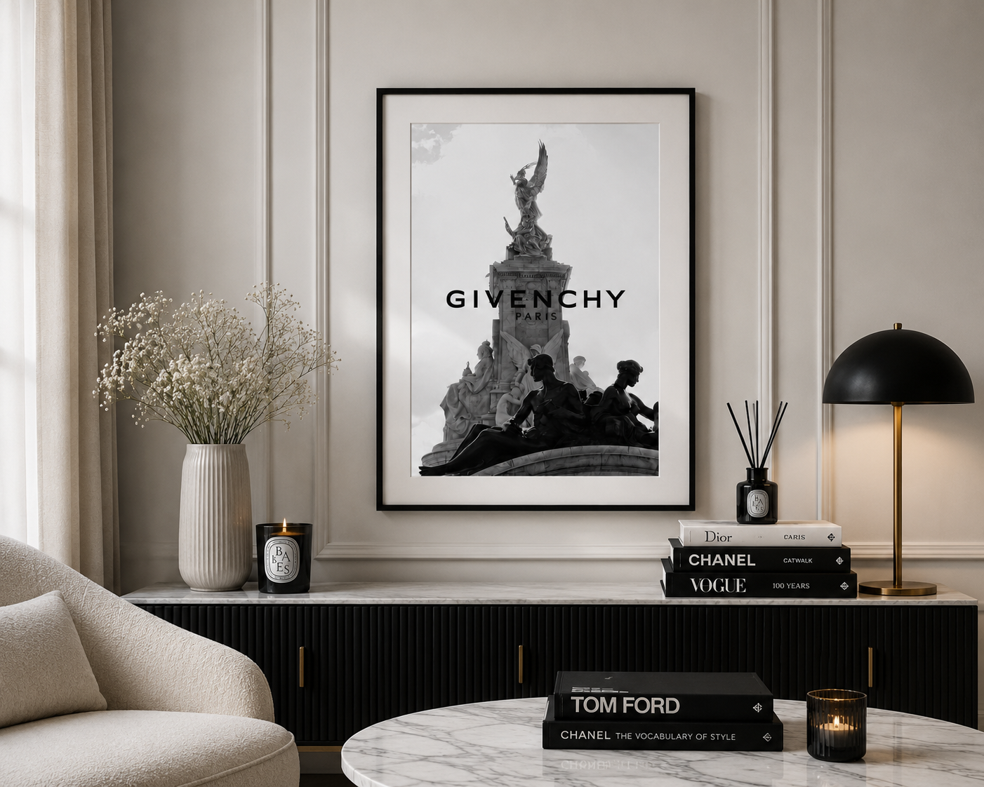 A framed black and white Givenchy Paris poster hangs on a beige paneled wall above a console table in a styled living room setting.