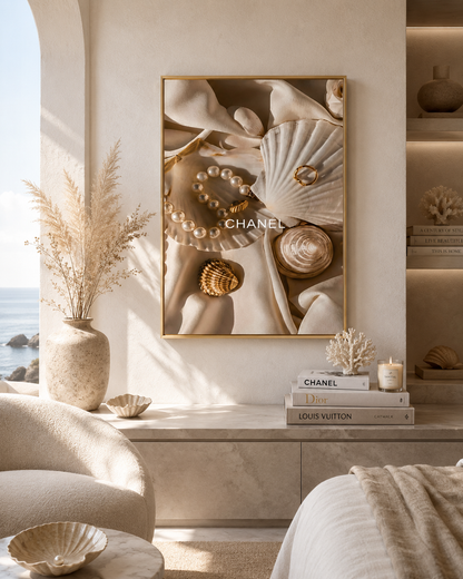 A framed wall art print featuring seashells, pearls, and a ring in warm beige and cream tones, displayed in a luxurious bedroom setting with a bed, a vase of dried grass, and books including Chanel and Louis Vuitton.