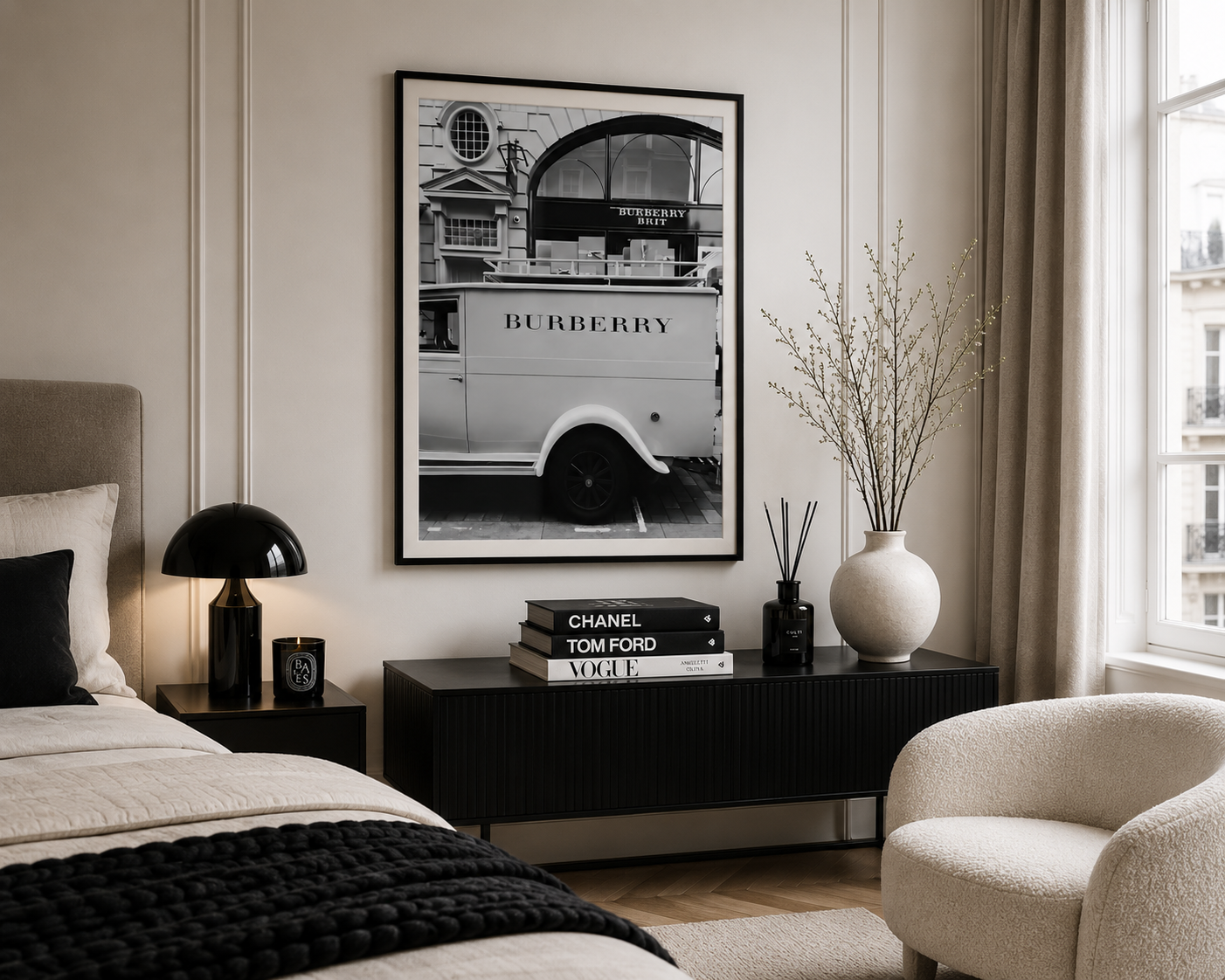 A framed black and white art print of a vintage Burberry double-decker bus hanging on a beige wall in a modern, elegantly styled bedroom.