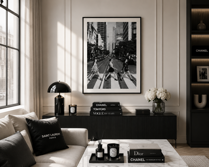 A black and white framed art print of the Abbey Road crosswalk scene, styled in a modern living room setting above a dark console table.
