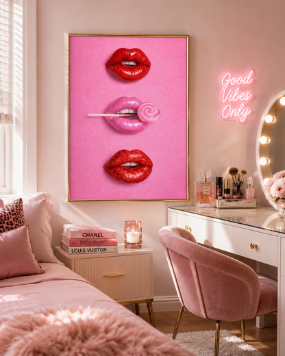 A framed wall art print featuring three pink-toned lips with red lipstick applied, hung above a vanity desk in a pink bedroom. The print is the product being shown, but the room setting makes this a Lifestyle image rather than a clean Product/Packaging shot.