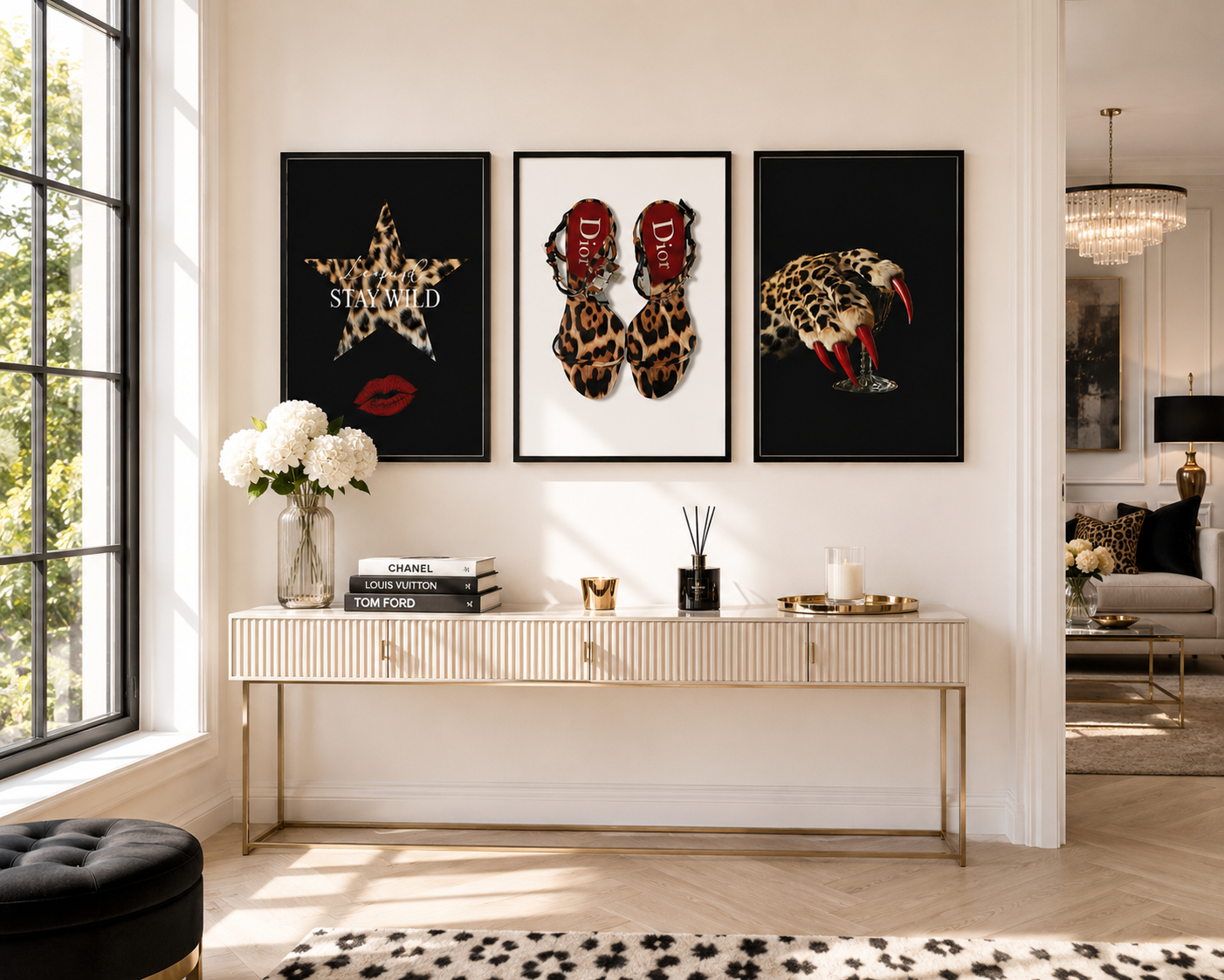 A styled interior scene showing three framed wall art prints hanging above a console table. The prints feature bold fashion-inspired designs: a leopard-print star with the word 'STUNN' on the left, red high-heel silhouettes with leopard-print feet in the center, and a leopard head with red tongue details on the right.