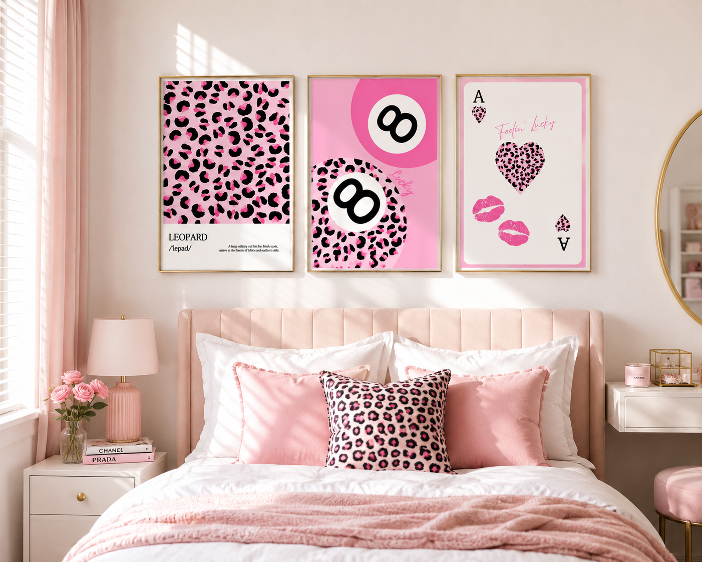 Three framed pink animal-print and graphic wall art prints displayed above a bed in a softly styled pink bedroom. The prints feature leopard print, pink-and-white number 8 graphics, and an Ace of Hearts design with lip marks.