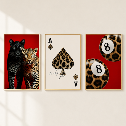 Three framed wall art prints displayed side by side on a light beige wall. The left print shows a black panther and leopard against a red background.