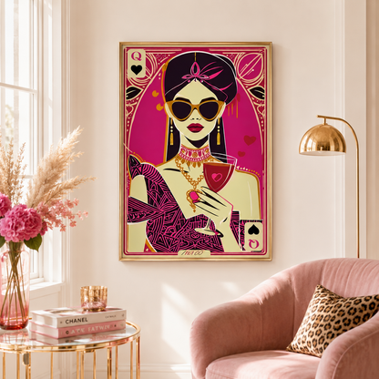 A framed art print featuring a stylized illustration of a woman in a pink and gold card-art design, hanging on a cream wall in a modern living room setting with a pink armchair, gold floor lamp, and side table.