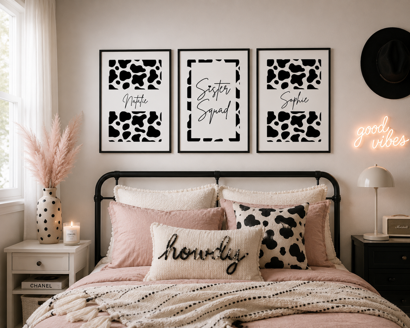 A styled bedroom scene with three framed black-and-white typography and animal-print wall art prints above a bed. The prints read 'Mothra', 'Sister Squad', and 'Sophia'.