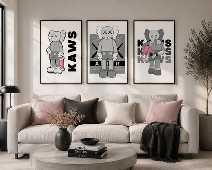 Three framed wall art prints featuring stylized KAWS characters in black, white, and gray, displayed above a beige sofa in a modern living room setting.
