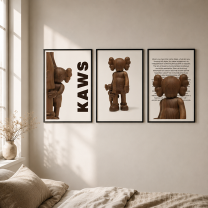 Three framed wall art prints featuring a brown woodenKAWS figure and text, displayed on a beige wall above a bed in a softly lit bedroom.