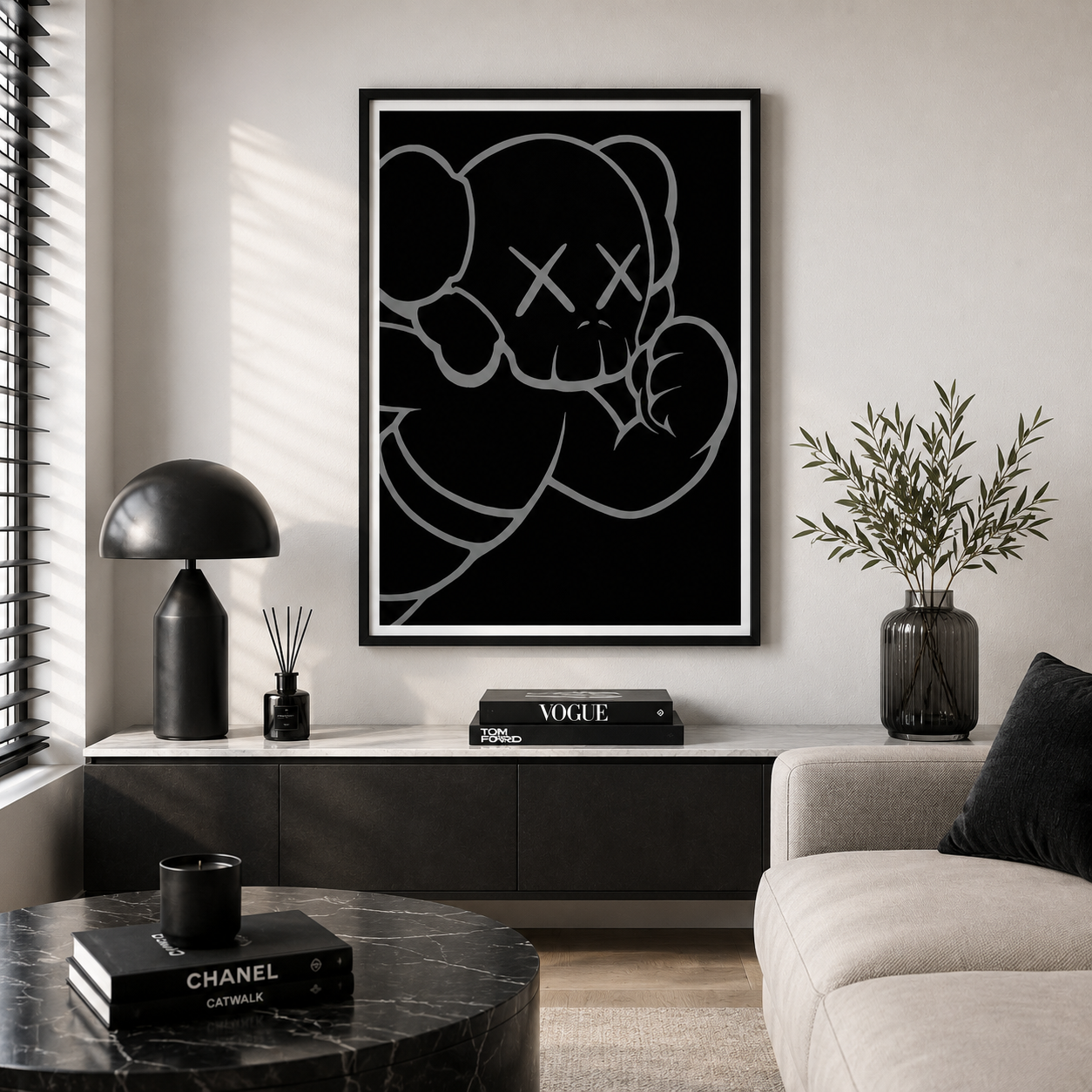 A framed black and white art print of a cartoon bear with X eyes hanging on a light gray wall in a modern living room setting.